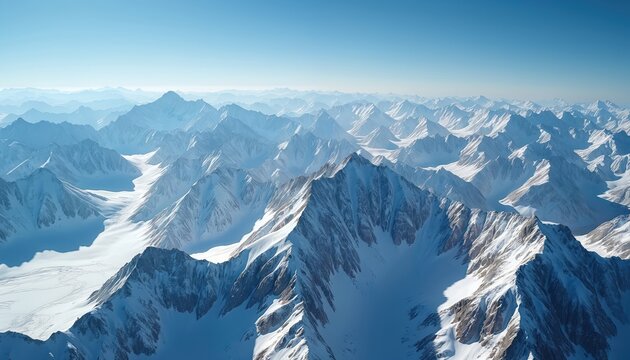 Vast snow-capped mountain ranges stretch to horizon under clear blue sky. Aerial view majestic peaks, glaciers, valleys covered in white snow. Cold, serene winter landscape perfect for travel,
