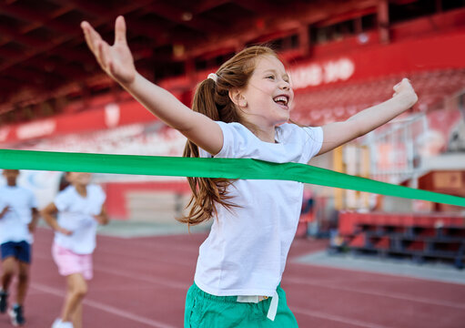 Young children having athletic exercise class running on the track, healthy lifestyle and children sport education concepts, finish line winner celebration, victory and success