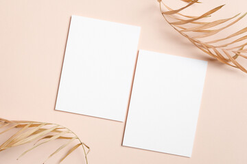 Blank white wedding invitation or greeting cards mockup with dried palm leaves, creating a serene and minimalistic aesthetic for design and creative projects, copy space