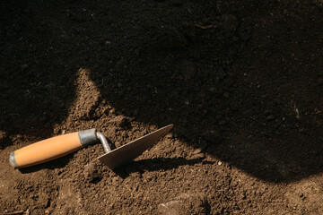 Shadow and Light on an Archaeological Scene. Archaeology trowels lying in the dirt of an excavation...