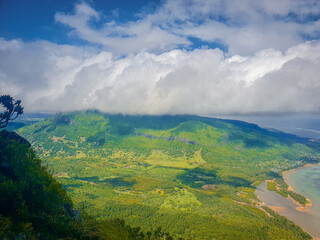 Dicht bewachsene grüne Berglandschaft von Mauritius mit Wolken in den Gipfeln