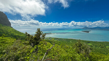 Weite Sicht mit grüner Landschaft und dem türkisblauen Meer auf Mauritius bei sehr gutem Wetter