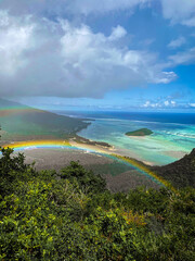 Panorama der grünen Berglandschaft von Mauritius mit buntem Regenbogen
