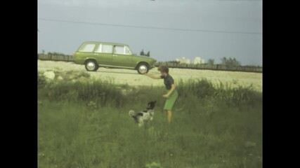 Woman playing with her dog in a field near denia, spain, 1969