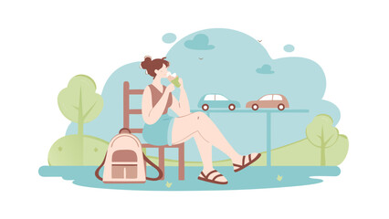 A woman sitting on a chair in a park with a backpack and two cars in the background on a sunny day