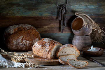 Fresh sliced bread and home utensils on wooden table