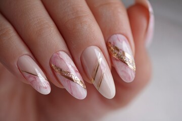 Closeup shot of a hand featuring almondshaped nails with marble and gold stripe designs