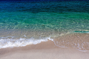 Crystal-clear emerald colored sea wave touches pristine sandy beach. Koh Adang, Thailand. Awesome sea background.