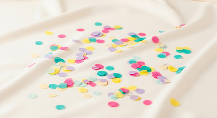 Colorful Confetti on White Fabric Background for Celebration or Party Decoration