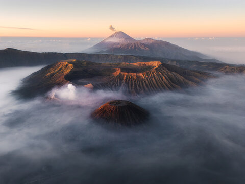 Aerial view of the Bromo-Tengger-Semeru National Park shrouded in ethereal mist, revealing the majestic Mount Bromo and Mount Semeru, Cemoro Lawang, East Java, Indonesia.