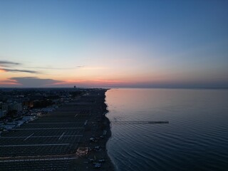 Seaside Serenity: Coastal town at the dusk, with gentle waves caressing the shore under a serene...