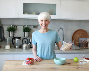 Portrait of a happy senior mature woman having a healthy breakfast after fitness exercise training...