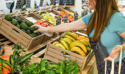 Female customer buying organic food fruits inside eco fresh local market - Healthy lifestyle and small business concept - Focus on hand