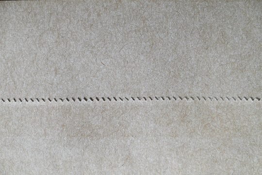 Perforated kraft paper texture background with zigzag seam