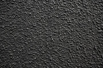 Closeup of a dark, rough, and grainy textured surface, abstract background