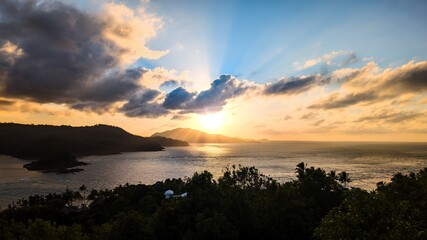 A majestic sunset with sunlight rays over tropical islands.