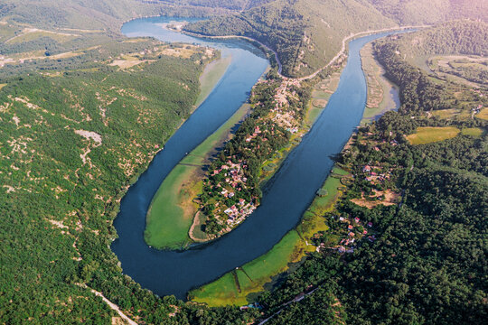 Aerial view of meandering river cutting through forested hills and mountains in Serbia, creating stunning scenery