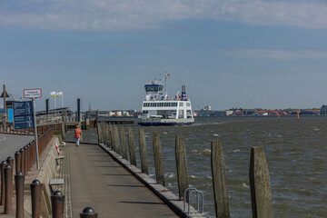 Fanø summer 2024, Denmark - Lady on the pier - view of the ferry between Esbjerg and Fanø