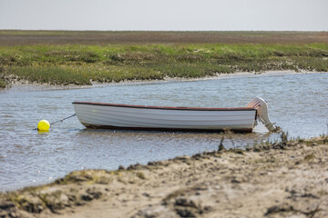 Fanø summer 2024, Denmark - Small dinghy with outboard motor lying on the shore