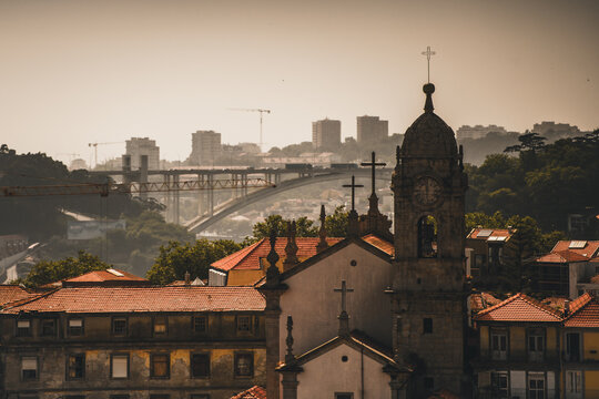Porto, Portugal - 17 June 2022: View of the Dom Lu&Atilde;&shy;s I Bridge stretching over the Douro River, framed by the intricate architecture of a historic church.