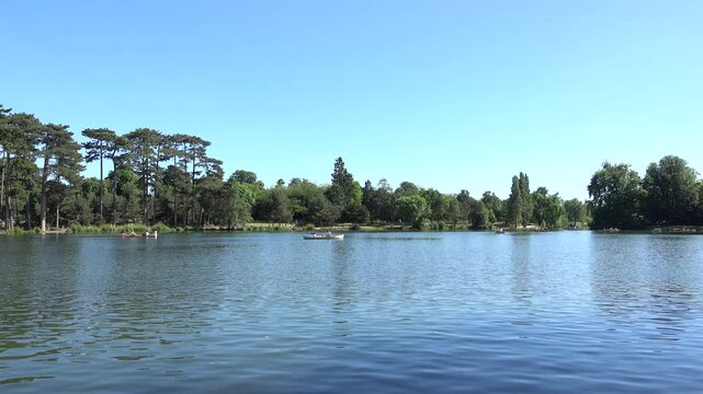 Vue sur un &eacute;tang &agrave; barques du bois de Boulogne en &eacute;t&eacute; par temps bleu ensoleill&eacute;