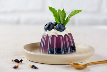 Purple jelly with fresh blueberries, mint, anchan tea and coconut cream with agar agar. Summer dessert, gelatin free.