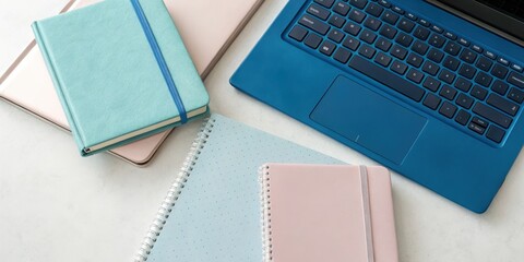 Colorful notebooks and laptop on desk: modern office workspace inspiration