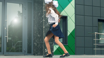 Happy school girl dancing and enjoying back to school