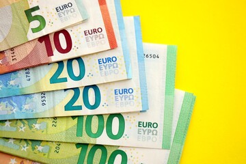 Big amount of european euro currency money notes on yellow color table close up