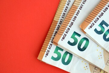 Big amount of european euro currency money notes on red color table close up