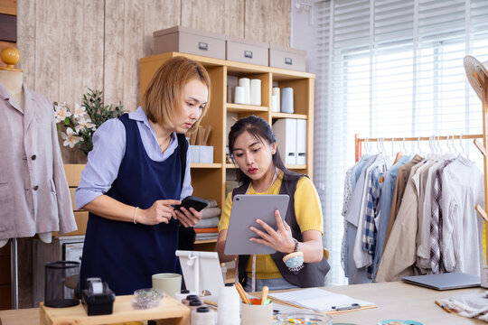 Small business designer woman, fashion design, customer consult using tablet workshop, creative boutique shop owner discusses custom clothing with client, planning customization and fitting service