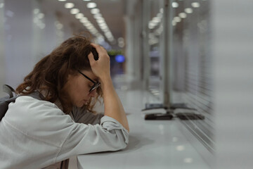 Unhappy young woman at closed cash front desk register window covering her face with her hands