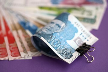 Pakistan rupees banknotes on purple background. The current Pakistan money bills