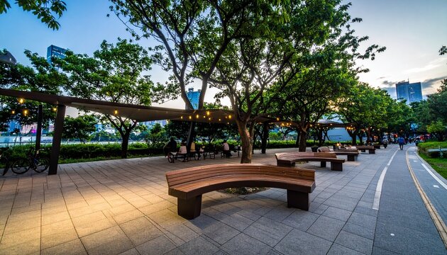 Modern city park at sunset with people relaxing, coffee in hand, under trees and string lights.
