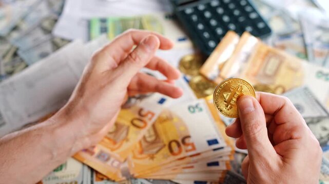 Hands shows BTC bitcoin against the dollars and euros