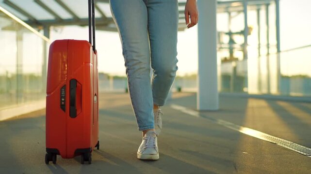Woman confidently pulling a suitcase in an airport terminal.