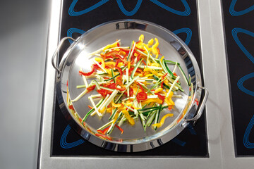 Sizzling Vegetable Stir-Fry in Stainless Steel Pan on Induction Cooktop