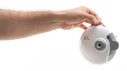 Hand holding a compact device in a studio setting