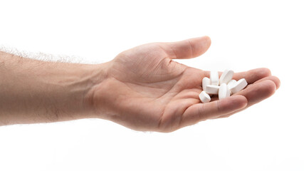 Hand with white tablets in bright light