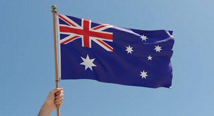 Patriotic Hand Holding Australian Flag Waving Against Clear Blue Sky