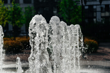 fountain of clean water in courtyard of residential complex, numerous jets of water, multi-storey...