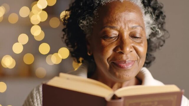 Senior African American Woman Reads a Book by Warm Bokeh Lights in a Cozy Indoor Setting Focused on Literature Knowledge and Relaxation