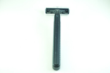 A close-up shot of a black disposable razor with a double blade, centered on a plain white...