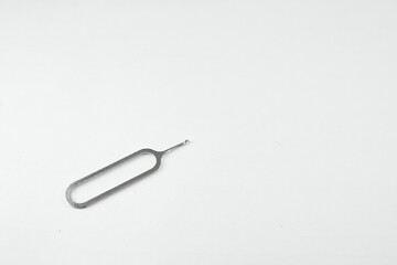 A single, metallic SIM card ejector tool on a plain white surface.