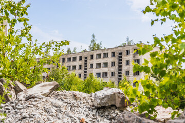 Overgrown Rubble in Irbene Ghost Town Frames Abandoned Soviet Apartment Block