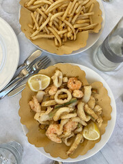 Seafood fritto misto and fries on outdoor table