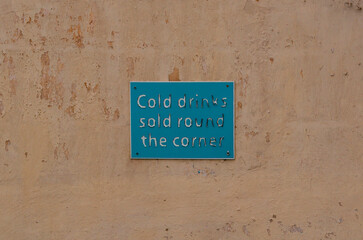 Rustic vintage drink sign on weathered wall