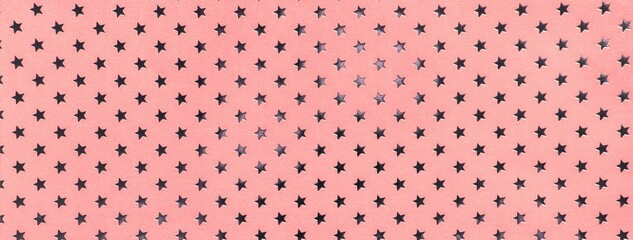 Light pink and rose paper background with metal foil pattern of silver stars for Christmas or New Year backdrop