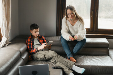 Teenager boy using game console and sad mother holding dice. Digital detox idea, online games, leisure activities and kids social media addiction. Choice video games for children, screen time