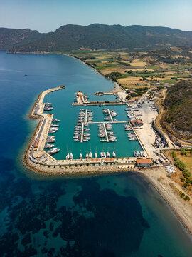 Aerial view of yachts nestled in Kormen Marina, azure waters meeting the rugged coastline under a clear sky, a tranquil scene., Datca, Mugla, T&Atilde;&frac14;rkiye.